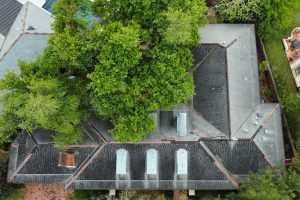 Aging residential roof with visible shingle deterioration and moss growth in the West Georgia area.